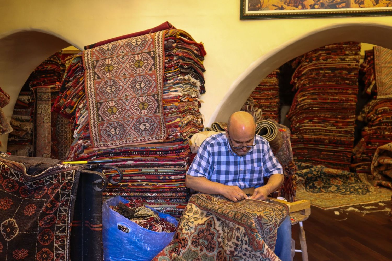 Artisan restaurant à la main un tapis ancien dans son atelier