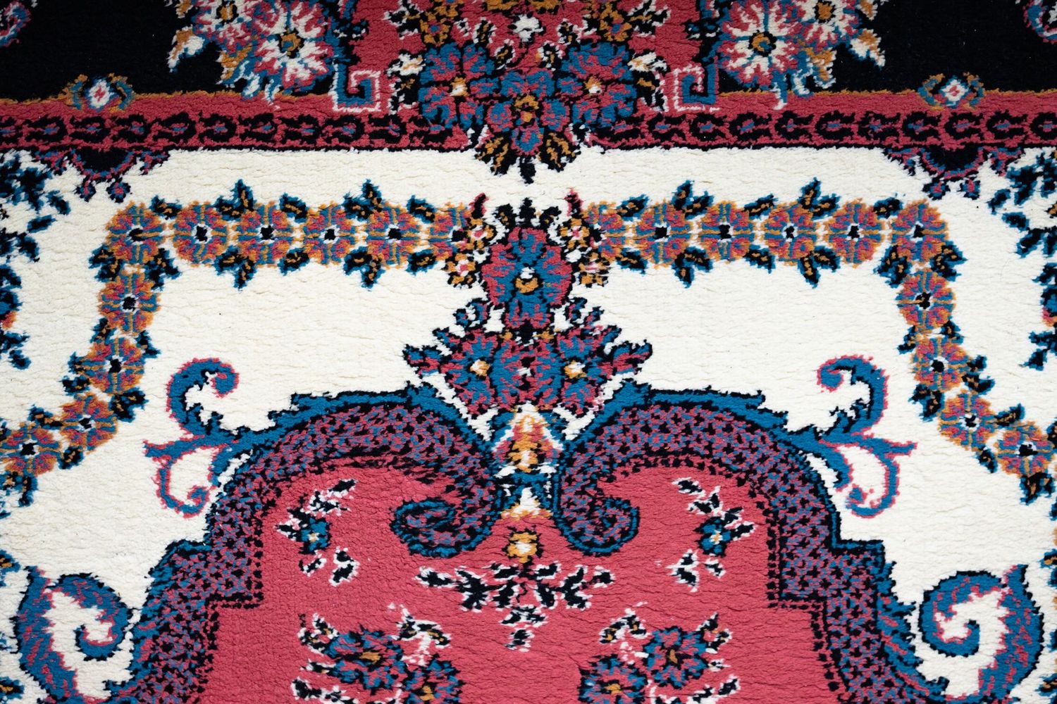 Tapis persan à décor floral et médaillon, rouge, bleu et ivoire